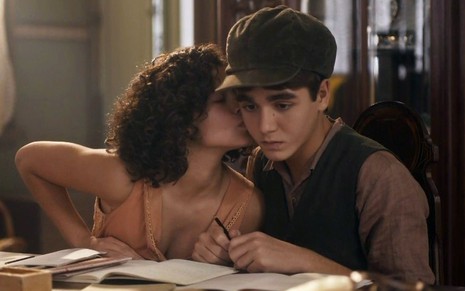 A atriz mirim Gabriella Saraivah, caracterizada como a Inês de Éramos Seis, beija o ator Xande Valois, o Carlos na novela, na bochecha