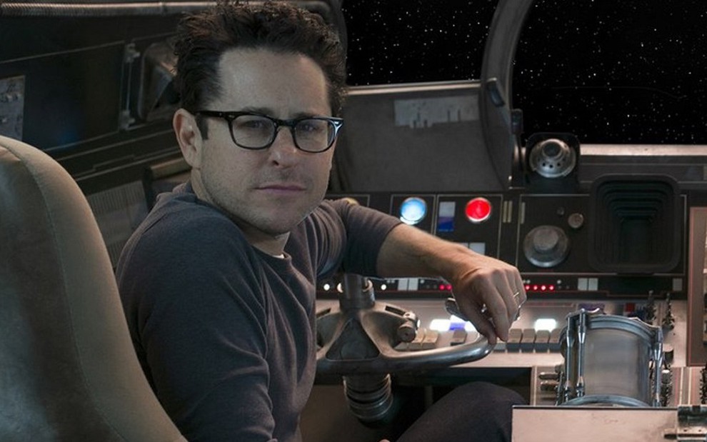 O diretor J.J. Abrams sentado em uma das naves do filme Star Wars: O Despertar da Força