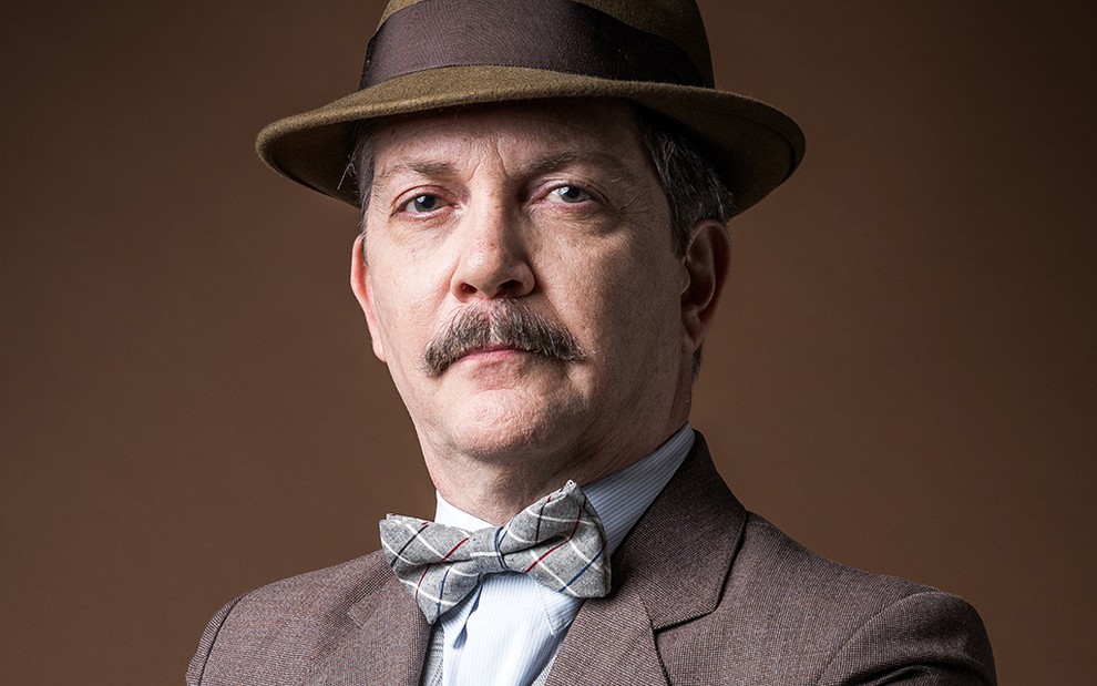 O ator Kiko Mascarenhas caracterizado como o personagem Virgulino em Éramos Seis, de chapéu, bigode e gravata borboleta