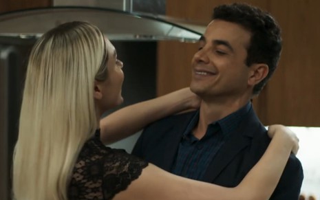 De costas, Monica Iozzi abraça Anderson Di Rizzi em cena como Kim e Márcio de A Dona do Pedaço, novela das nove da Globo