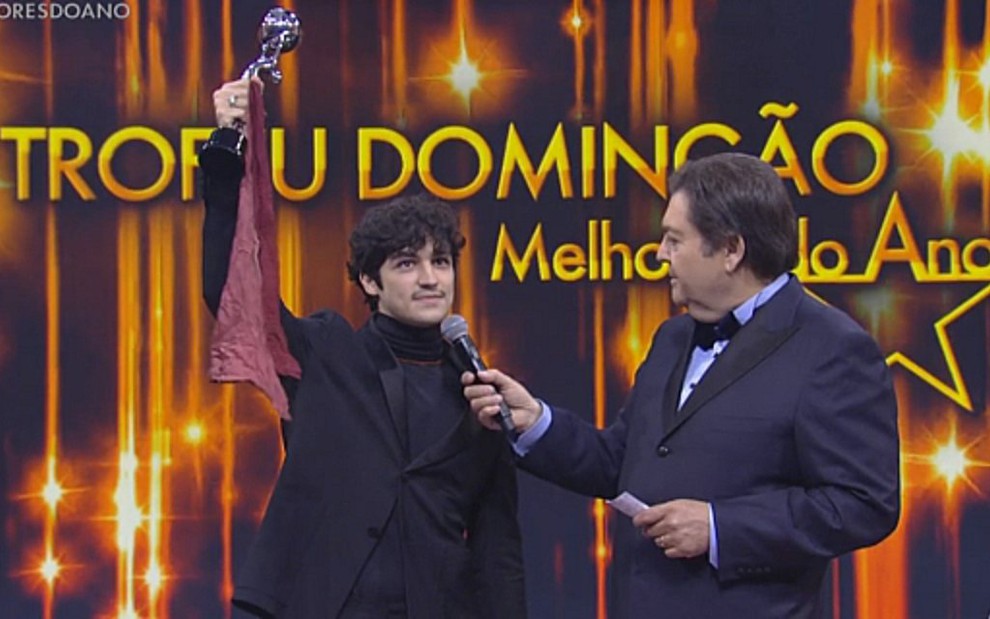 Gabriel Leone mostra a bandana de Domingos Montagner em homenagem no Faustão - Reprodução/TV Globo