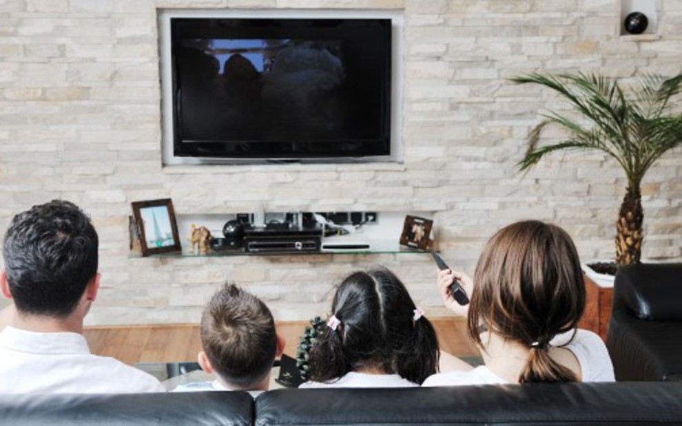 Família vê TV na sala; qualidade de definição da imagem depende da disposição do aparelho na casa - Reprodução