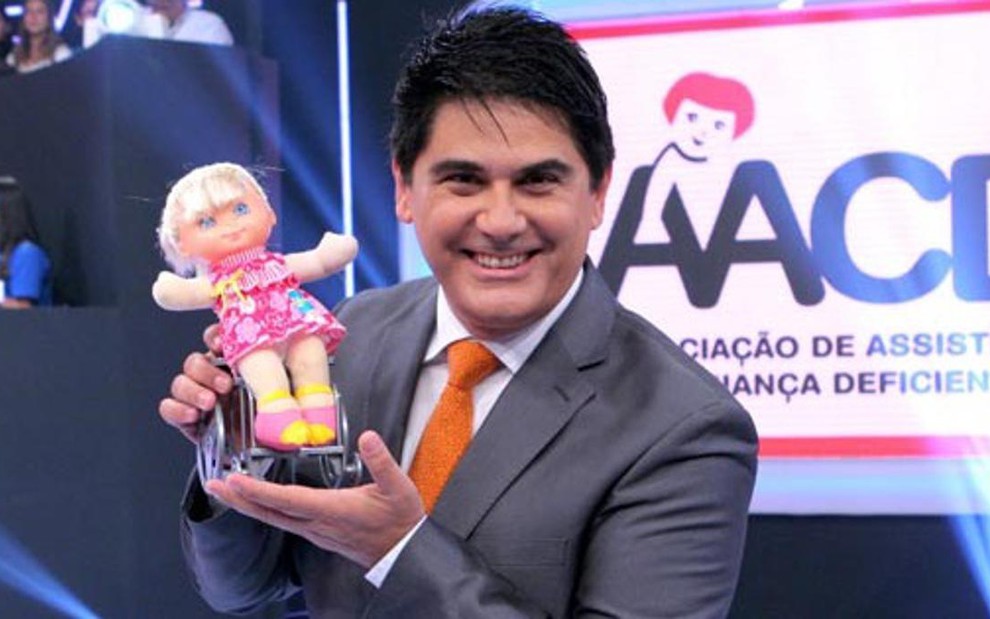 O apresentador César Filho segura a boneca Hebinha durante o Teleton de 2012 - Divulgação/SBT