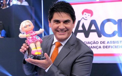 O apresentador César Filho segura a boneca Hebinha durante o Teleton de 2012 - Divulgação/SBT
