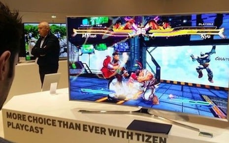Telespectador em frente a televisor conectado da Samsung com videogame em feira de TV - Fotos Reprodução