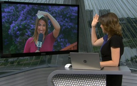 A repórter Ananda Apple se protege da chuva ao conversar com a apresentadora Glória Vanique, da Globo - Reprodução/TV Globo