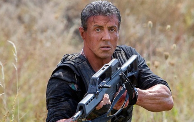 O ator Sylvester Stallone segura metralhadora em cena do filme Os Mercenários 3, de 2014 - Divulgação/Lionsgate