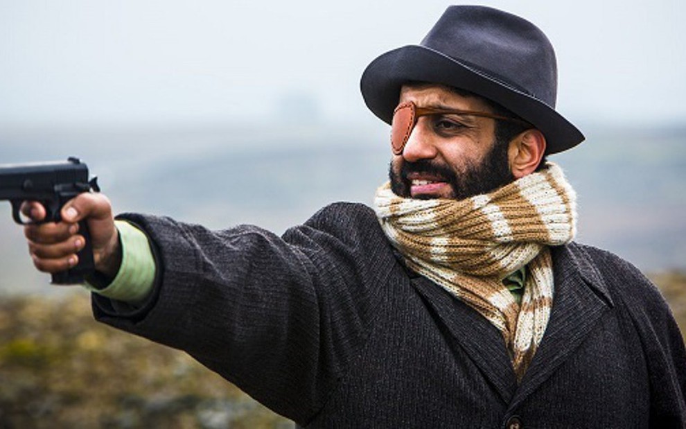 O ator Adeel Akhtar se prepara para atirar em Utopia, que estreia na madrugada de quinta no I.Sat - Fotos Divulgação/Channel 4