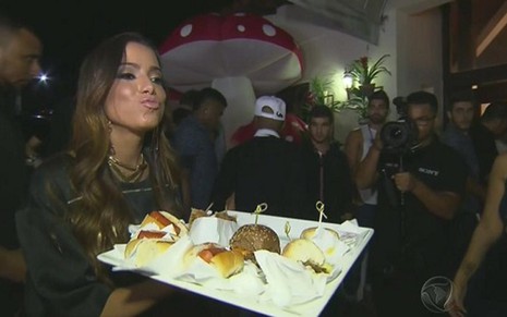 Anitta segura bandeja de sanduíches de sua festa; Câmera Record sobre aniversário da cantora bateu Jô - Reprodução/TV Record