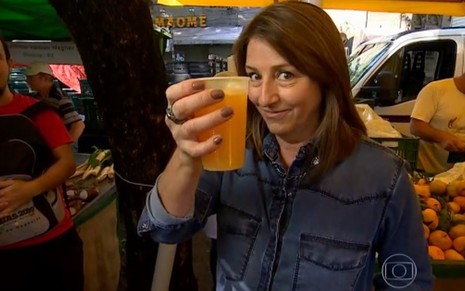 A repórter Rosane Marchetti brinda com suco de laranja em feira de produtos orgânicos de Porto Alegre - Reprodução/TV Globo