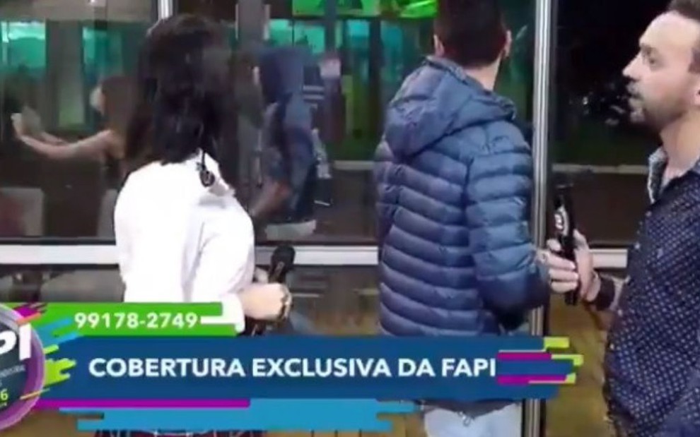 O prefeito Lucas Pokay (ao centro) dava entrevista para TV local quando foi surpreendido por briga - REPRODUÇÃO/YOUTUBE