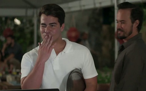 Júlio (Thiago Martins) manda beijinho para cliente e é observado por Evandro (Paulo Vilhena) - Reprodução/TV Globo