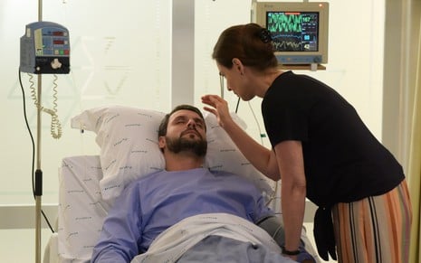 Antonio (Felipe Cunha) no leito do hospital com Mariinha (Sílvia Pfeifer) em cena da novela Topíssima, da Record