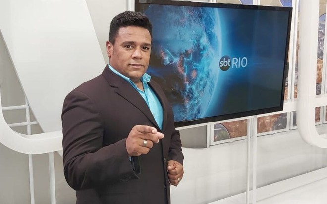 Repórter Caio Alex no cenário do jornal SBT Rio