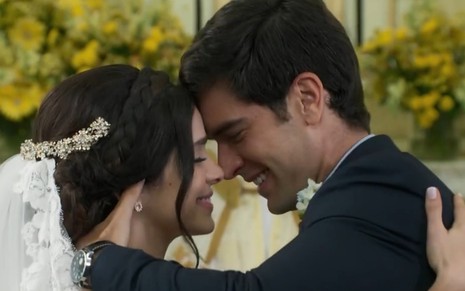 Sabrina Petraglia vestida de noiva e Marcos Pitombo de terno durante casamento do casal Shirlei e Felipe em Haja Coração (2016)