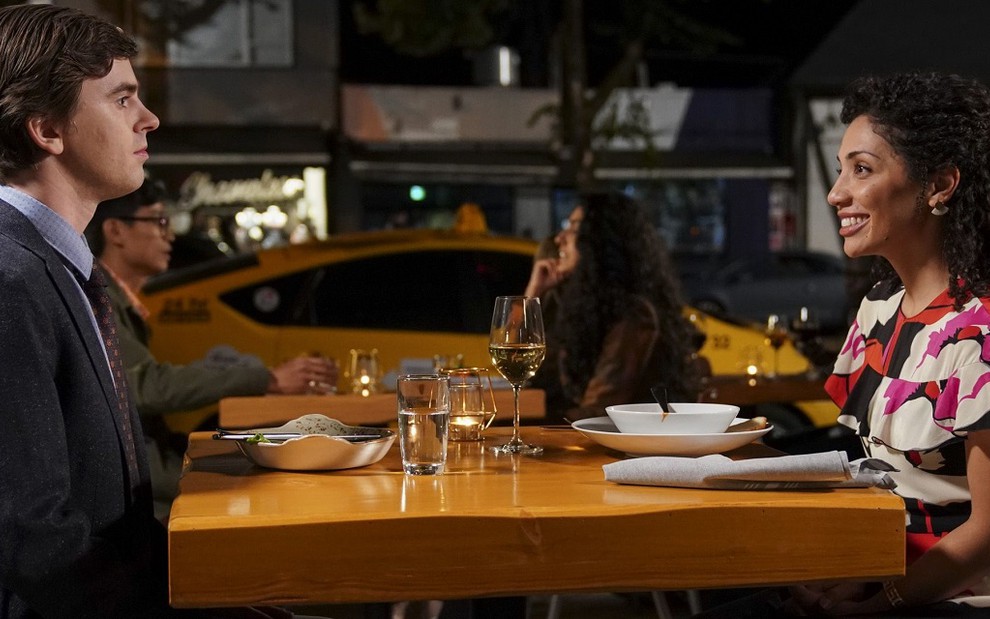 Os atores Freddie Highmore e Jasika Nicole sentados em uma mesa de restaurante na série The Good Doctor
