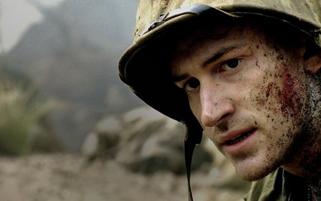 O ator Joseph Mazzello, vestido de soldado e com a cara manchada de sangue, em cena da minissérie The Pacific