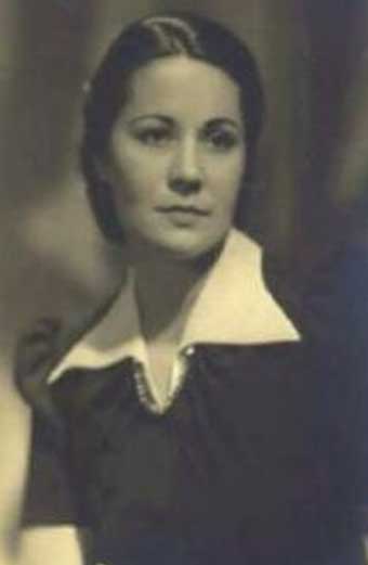 Uma fotografia real de Aracy de Carvalho, em sépia, com um vestido preto e cabelos, também pretos, presos atrás da cabeça. Ela é muito branca.