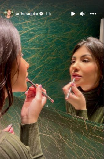Mulher se maquia em frente ao espelho