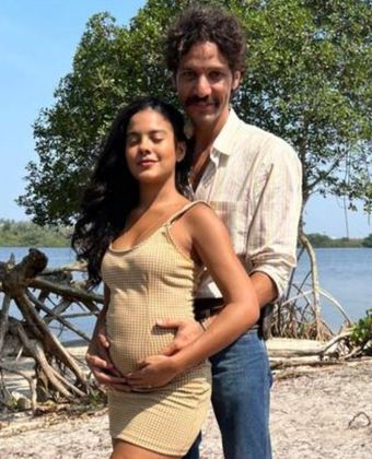 Bella Campos, com barriga de grávida, é abraçada por trás por Guito
