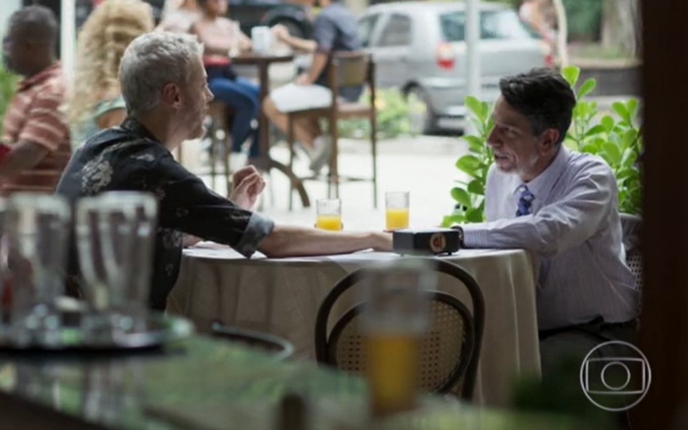 Douglas e Siqueira estão sentados em uma mesa num restaurante