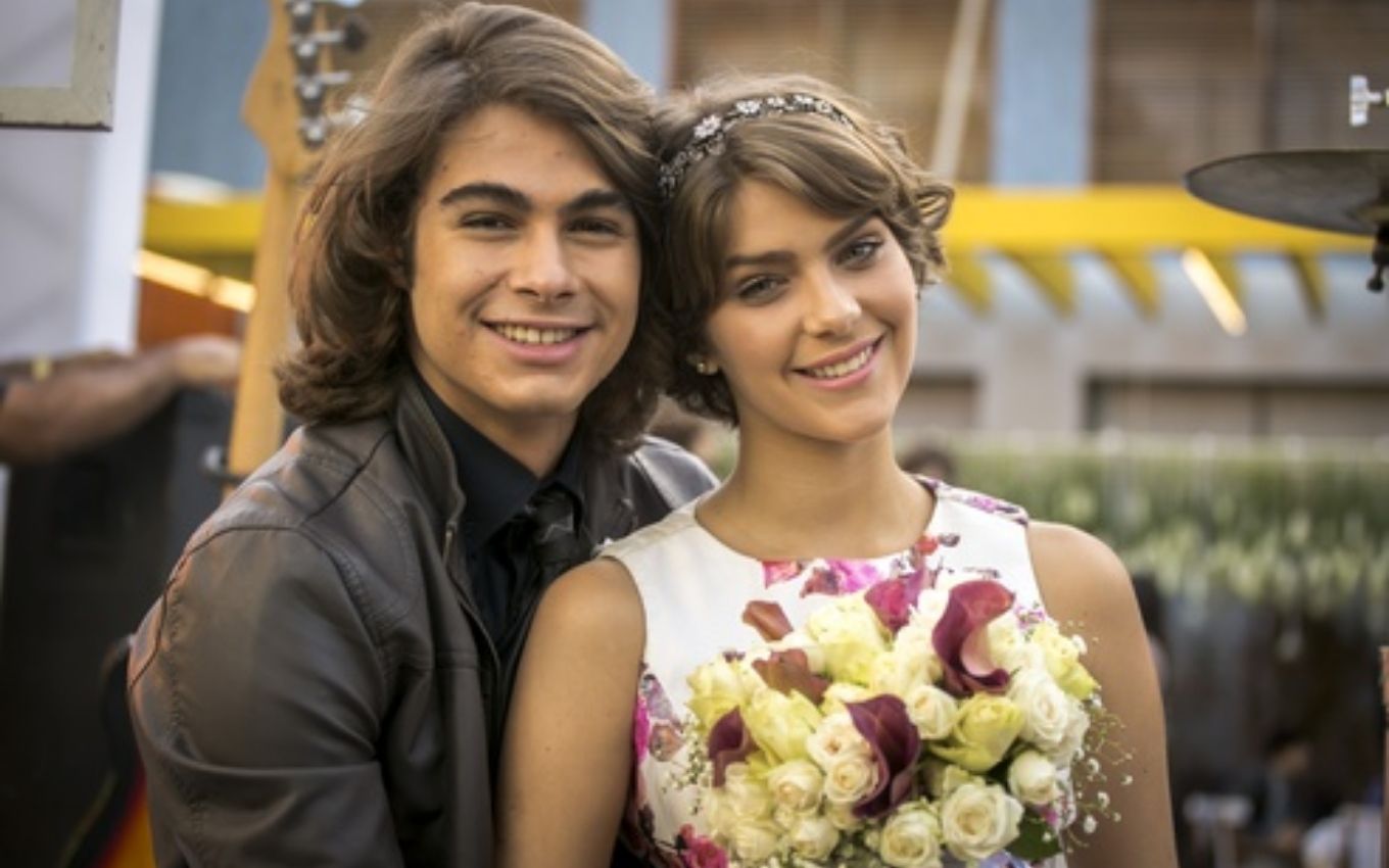 Rafael Vitti e Isabella Santoni abraçados, ela segurando buquê de flores, como Pedro e Karina em Malhação Sonhos