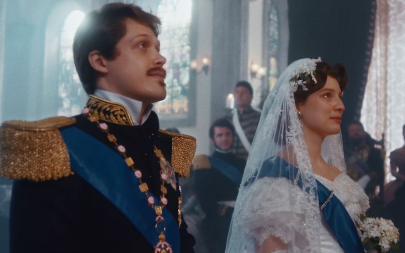 O ator Daniel Torres e a atriz Giulia Gayoso, à beira do altar, como Gastão e Isabel em cena de casamento de Nos Tempos do Imperador