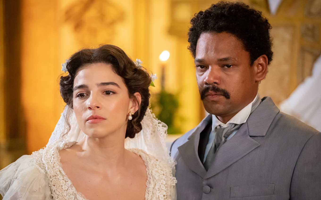 Vestida de noiva, a atriz Gabriela Medvedovski está caracterizada como Pilar à esquerda, ao lado de Michel Gomes, o Samuel, em cena de Nos Tempos do Imperador