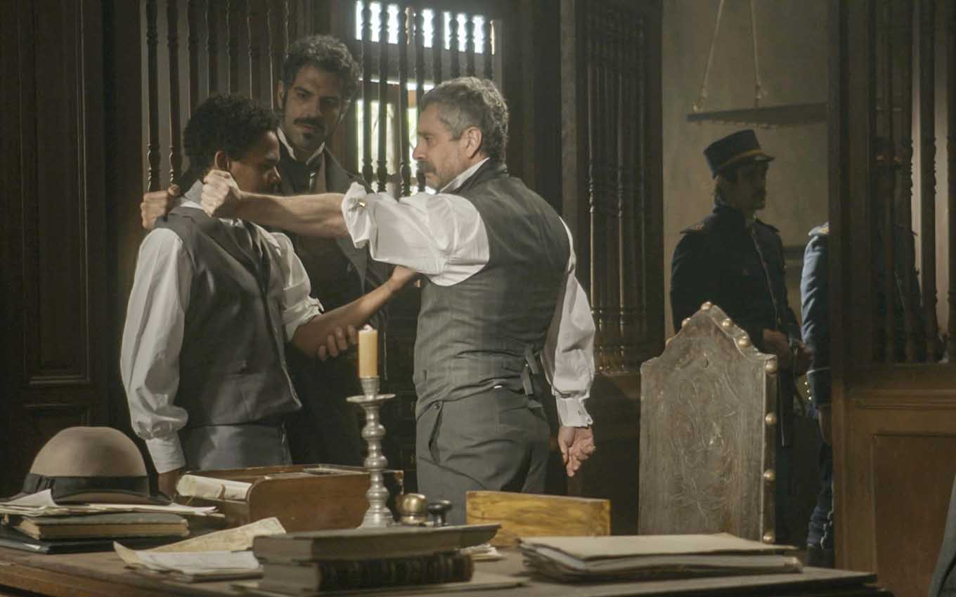 O ator Michel Gomes como Samuel se surpreende ao ver uma marca de nascença no braço de Tonico, interpretado por Alexandre Nero, em cena de Nos Tempos do Imperador 