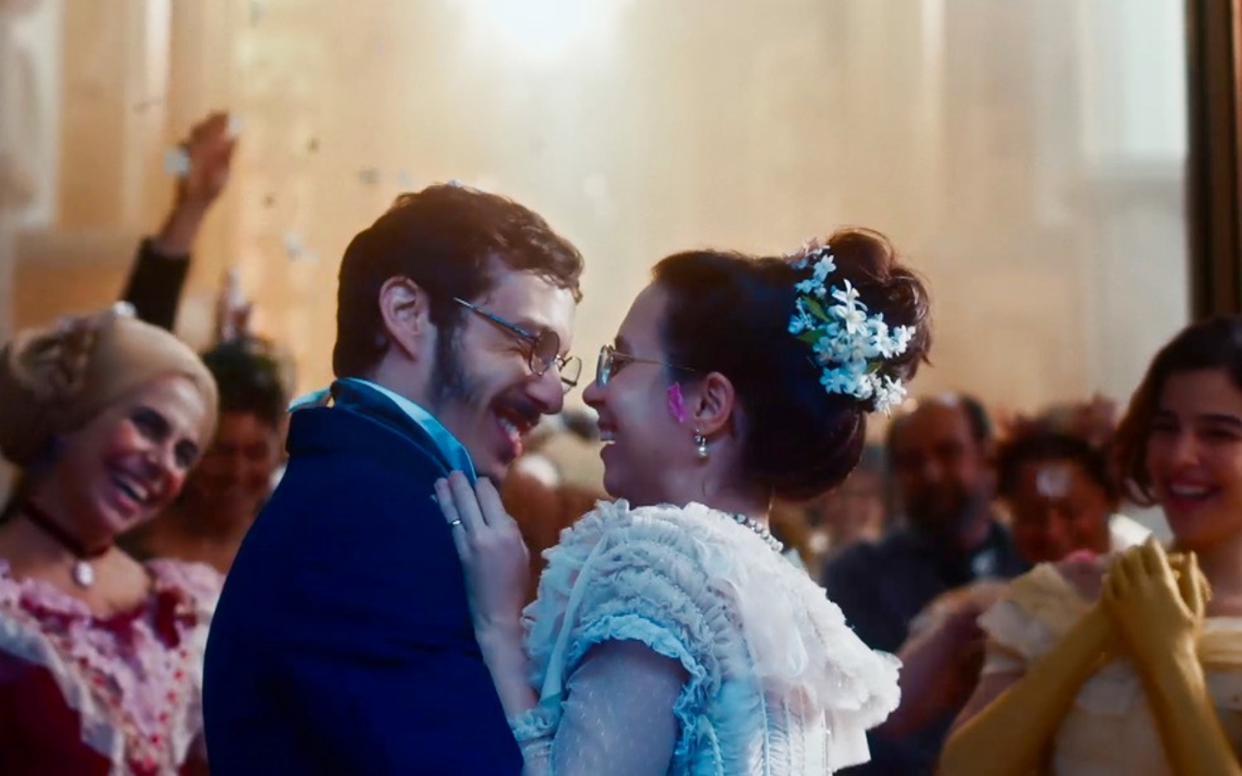 João Pedro Zappa, caracterizado como Nélio, e Daphne Bozaski, a Dolores, se beijam na cerimônia de casamento em Nos Tempos do Imperador