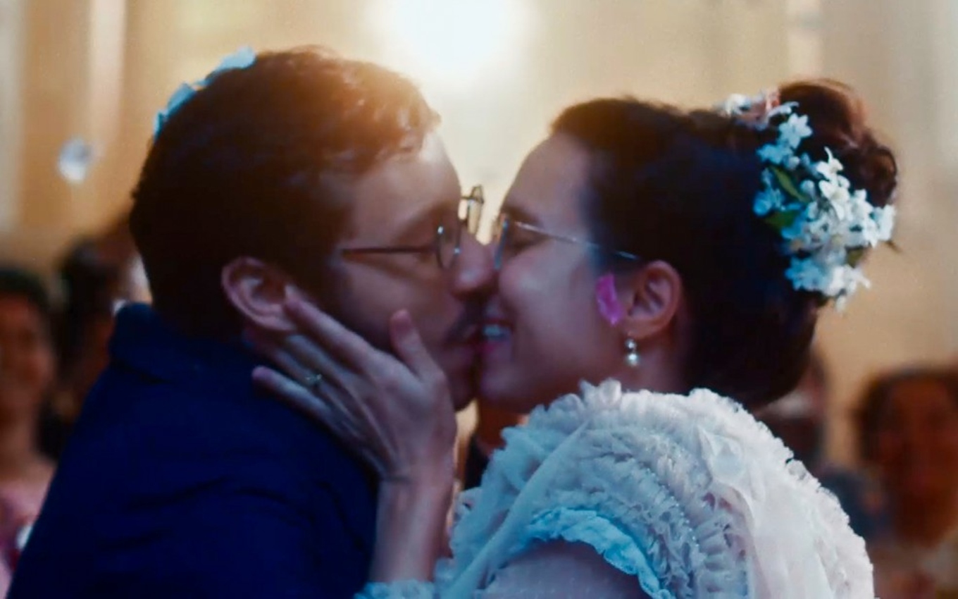 João Pedro Zappa, caracterizado como Nélio, e Daphne Bozaski, a Dolores, se beijam na cerimônia de casamento em Nos Tempos do Imperador