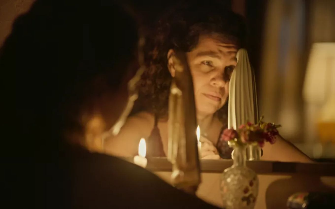 Isabel Teixeira grava cena chorando olhando para santa, como Maria Bruaca