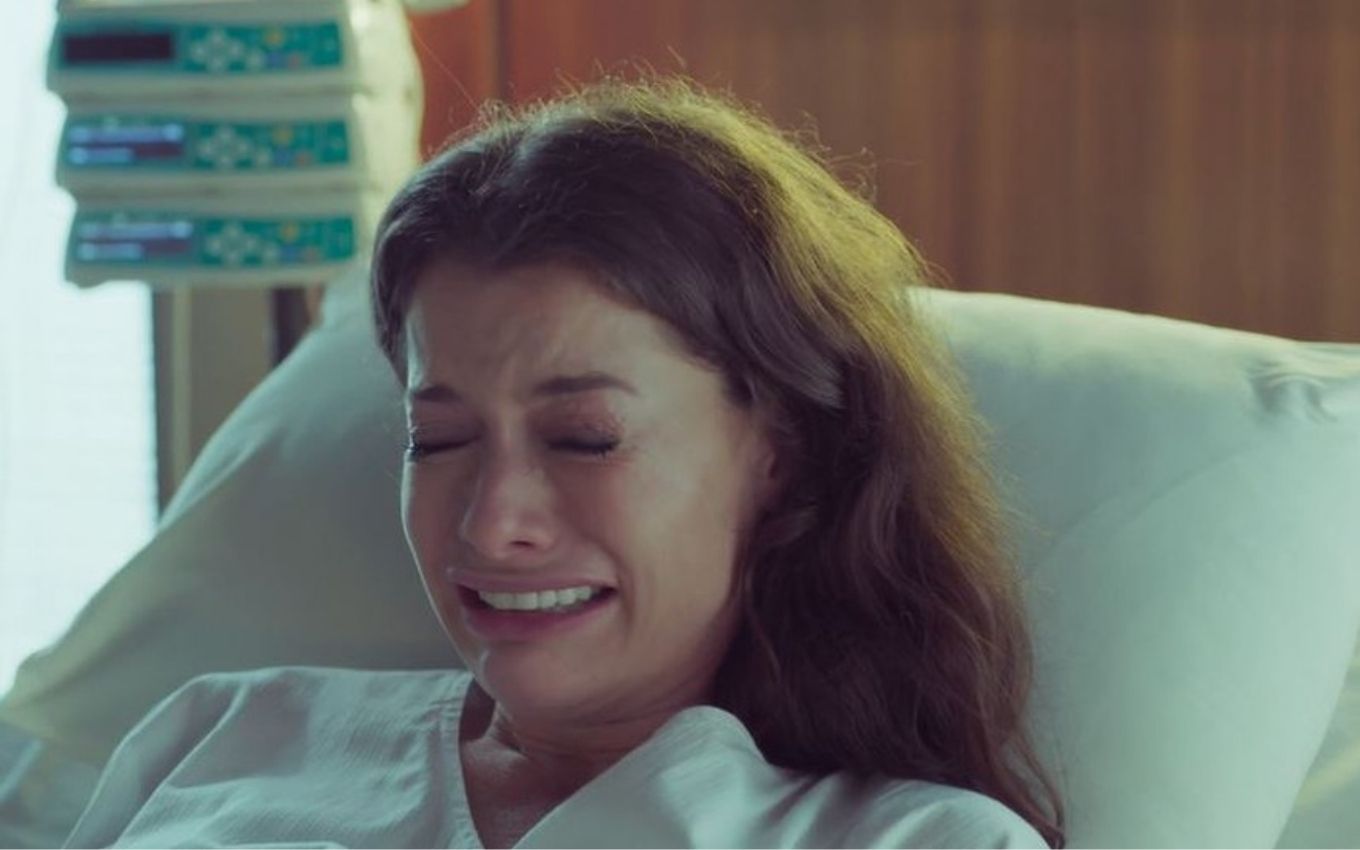 A atriz Alinne Moraes como Bárbara chora em uma cama de hospital em cena de Um Lugar ao Sol