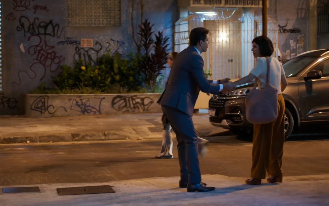 Cauã Reymond, caracterizado como Renato, aperta braço de Andreia Horta, a Lara, em cena de Um Lugar ao Sol