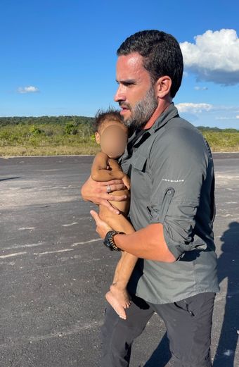 João Paulo Vergueiro carrega criança Yanomami