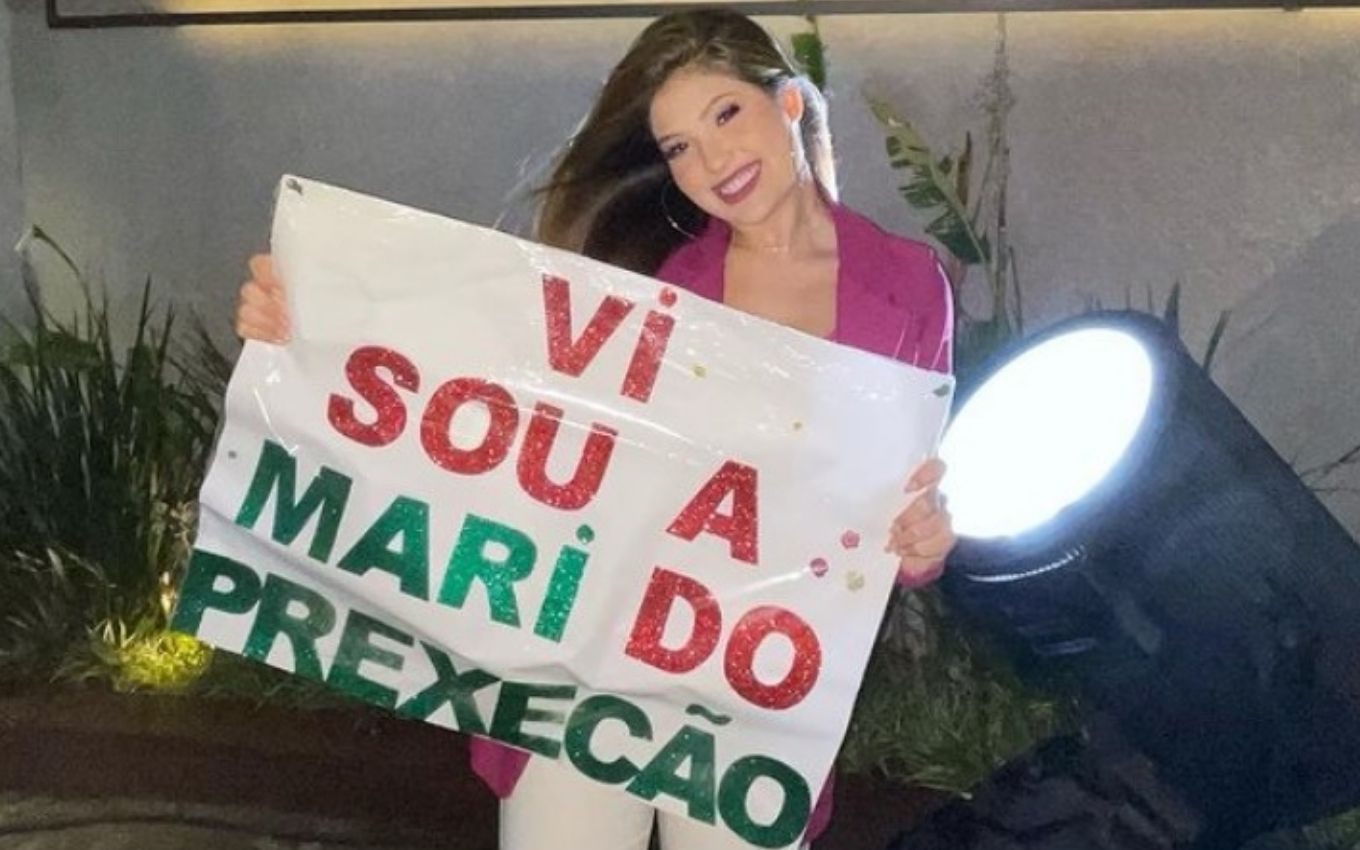 Mari Menezes com o cartaz de Prexecão para Virginia Fonseca