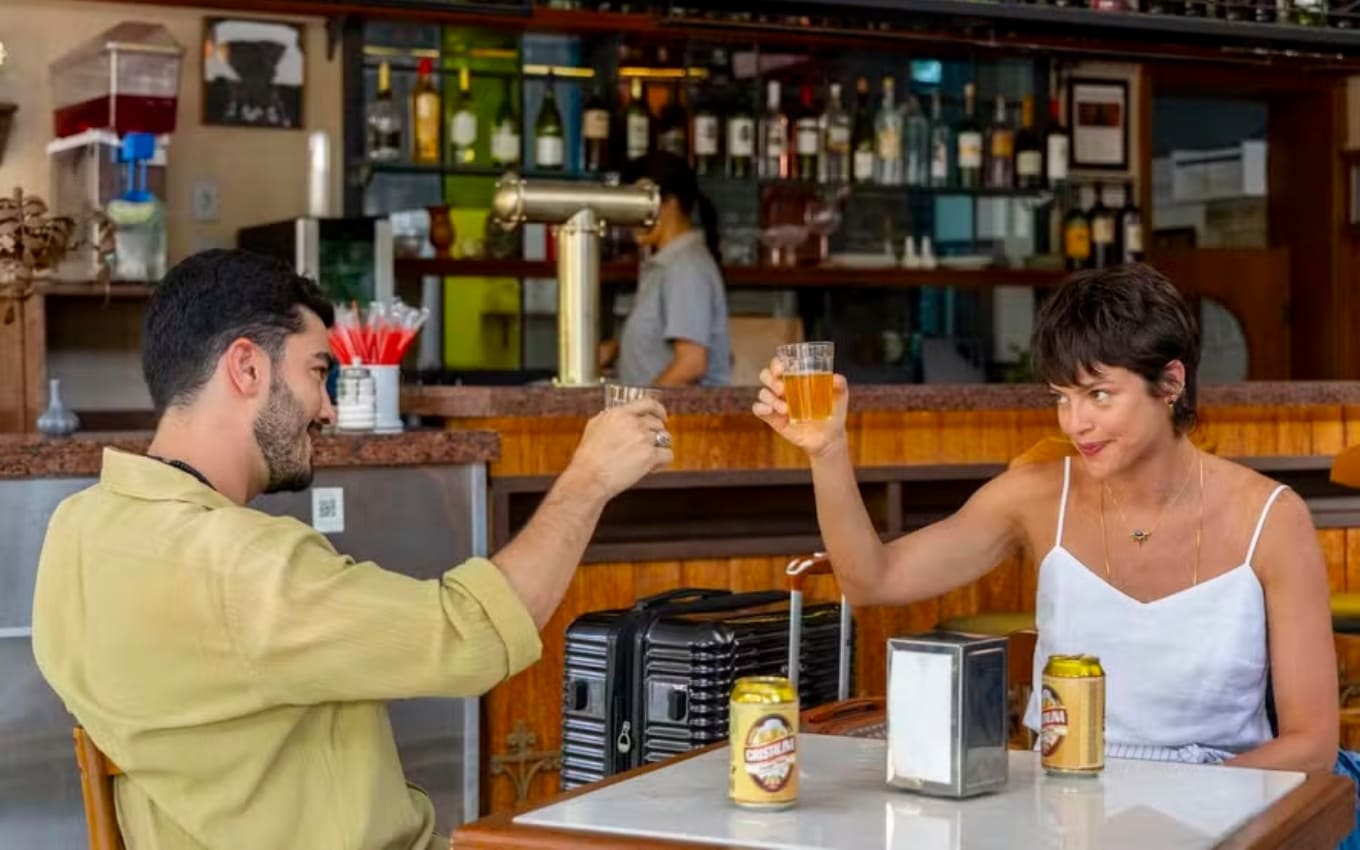 Rodhes (Leonardo Bittencourt) e Luma (Agatha Moreira) em mesa de bar de Mania de Você